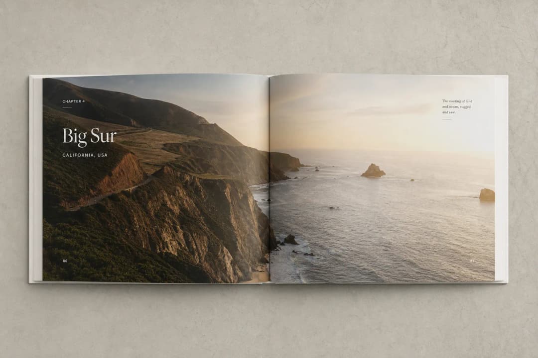 Open coffee table photo book with panoramic travel photography across a double-page spread